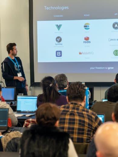 Shopware employee presents a slide about technologies like Vue.js or Symfony to Shopware Hackathon participants.
